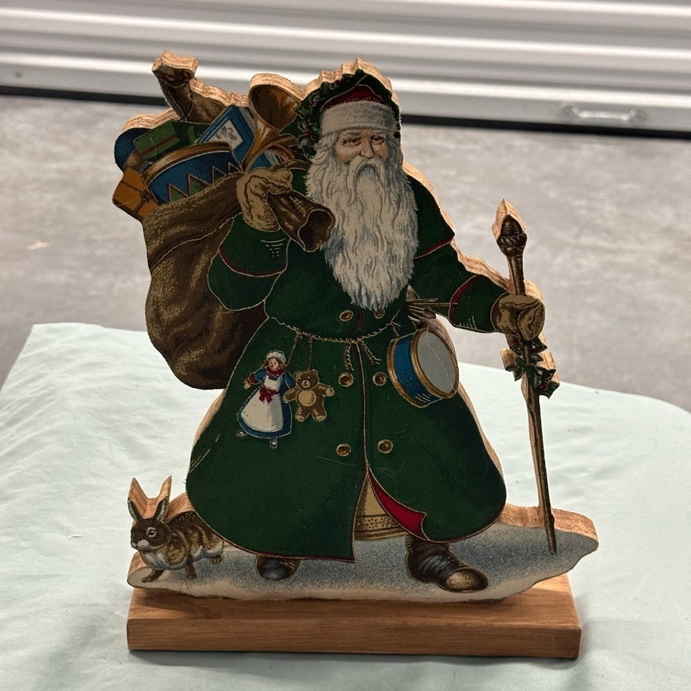Wooden vintage Santa figure wearing beautiful green robes.